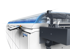 Hunkeler GEN8 EVO – Modulares Digitaldruck-Finishing-System mit innovativem Industrial Design von Alphagate. Die transparente Schnittansicht zeigt die Verarbeitungstechnik, während das blaue Licht den laufenden Betrieb signalisiert.