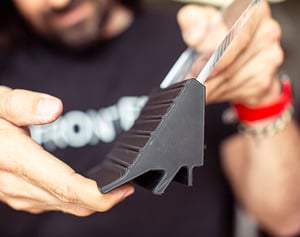 Detailaufnahme eines Mannes bei der Begutachtung eines industriellen Designstücks – klar definierte Formen, hochwertige Materialien und die Ästhetik industrieller Gestaltung.